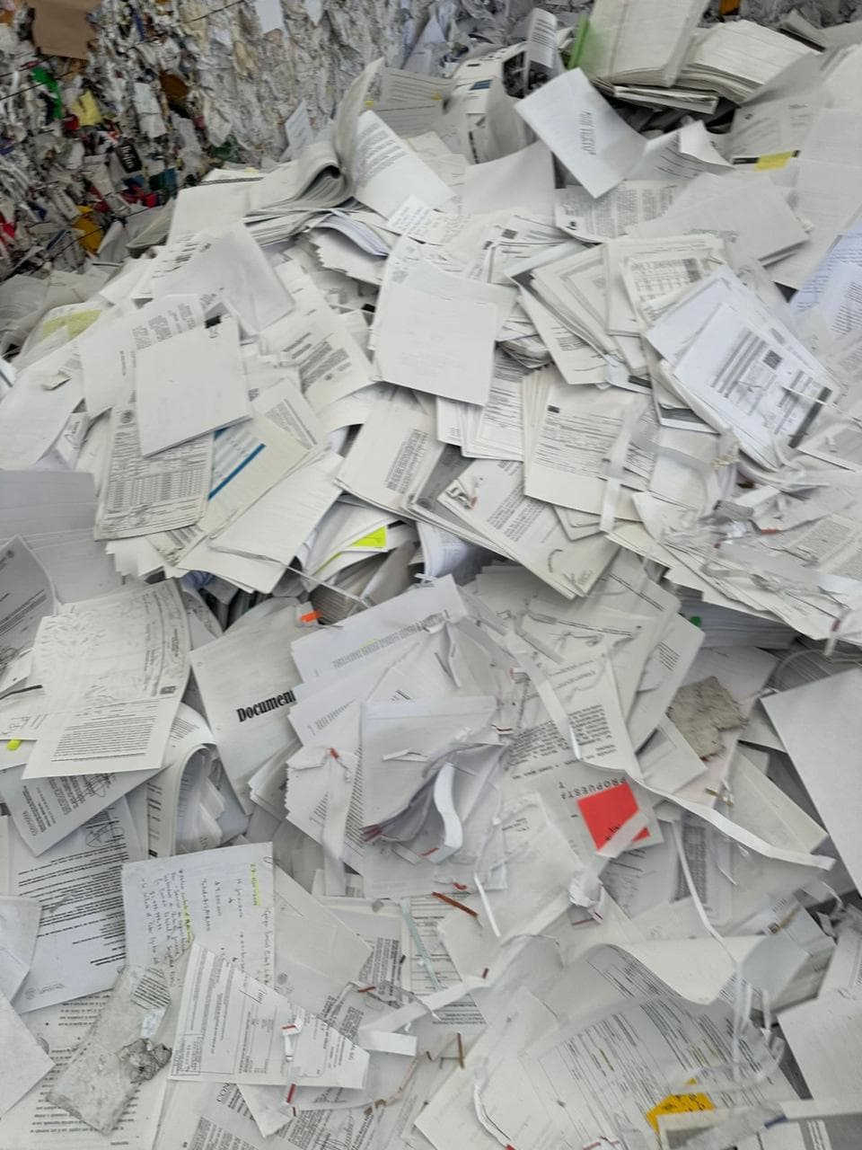 Documentos de papel y expedientes acumulados en el área de destrucción, listos para triturarse y reciclarse
