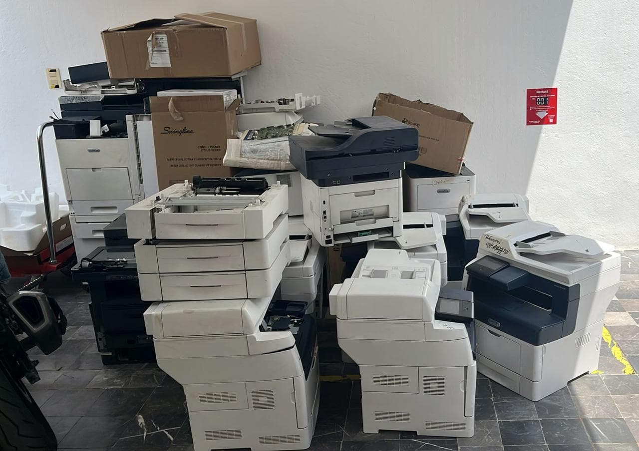 Impresoras multifuncionales y copiadoras acumuladas en una oficina antes de su reciclaje