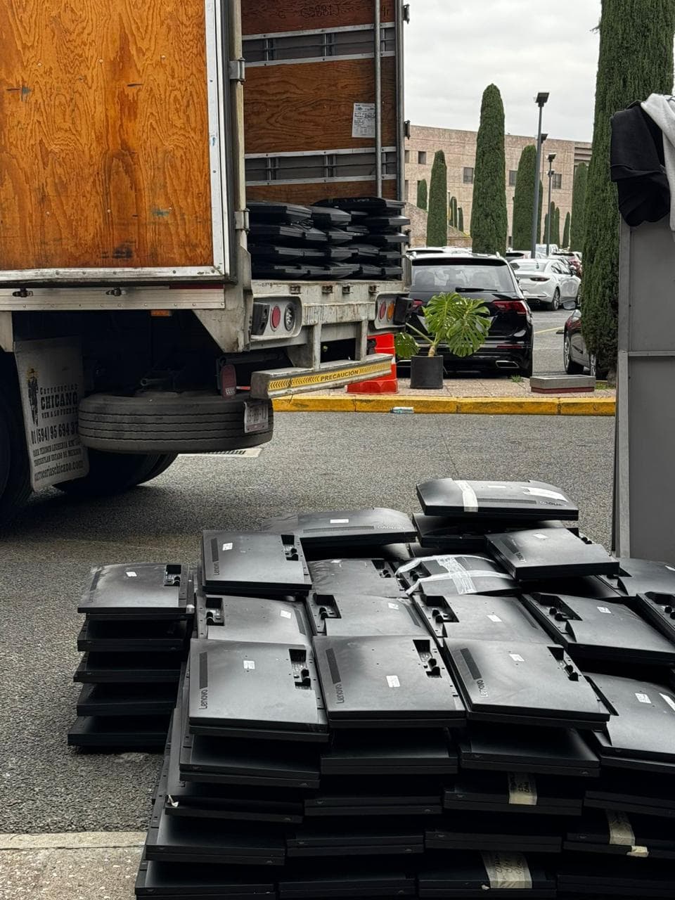Monitores en desuso apilados junto a la unidad de recolección, listos para cargarse