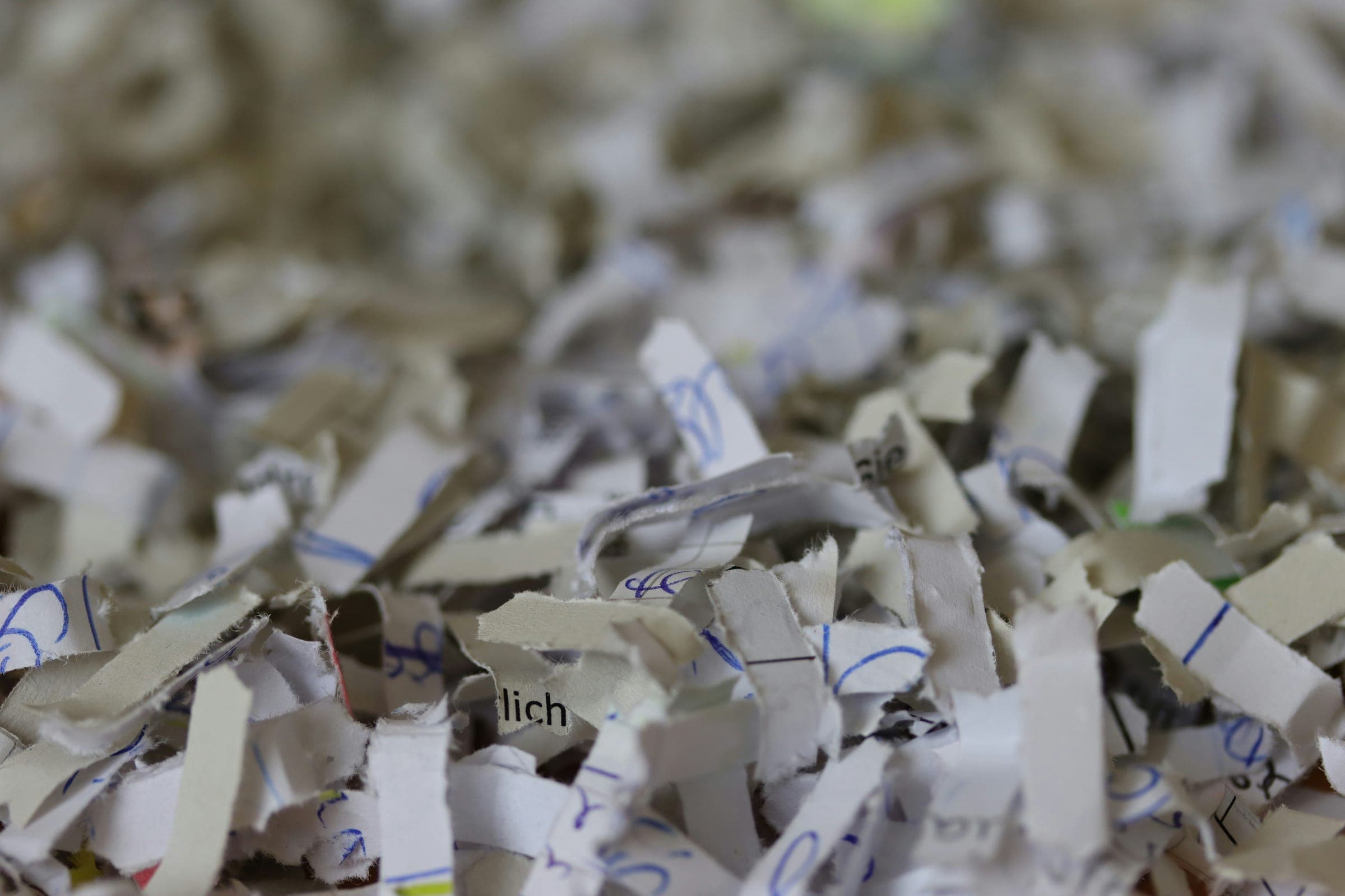 Acercamiento a tiras de papel triturado con restos de escritura ilegibles