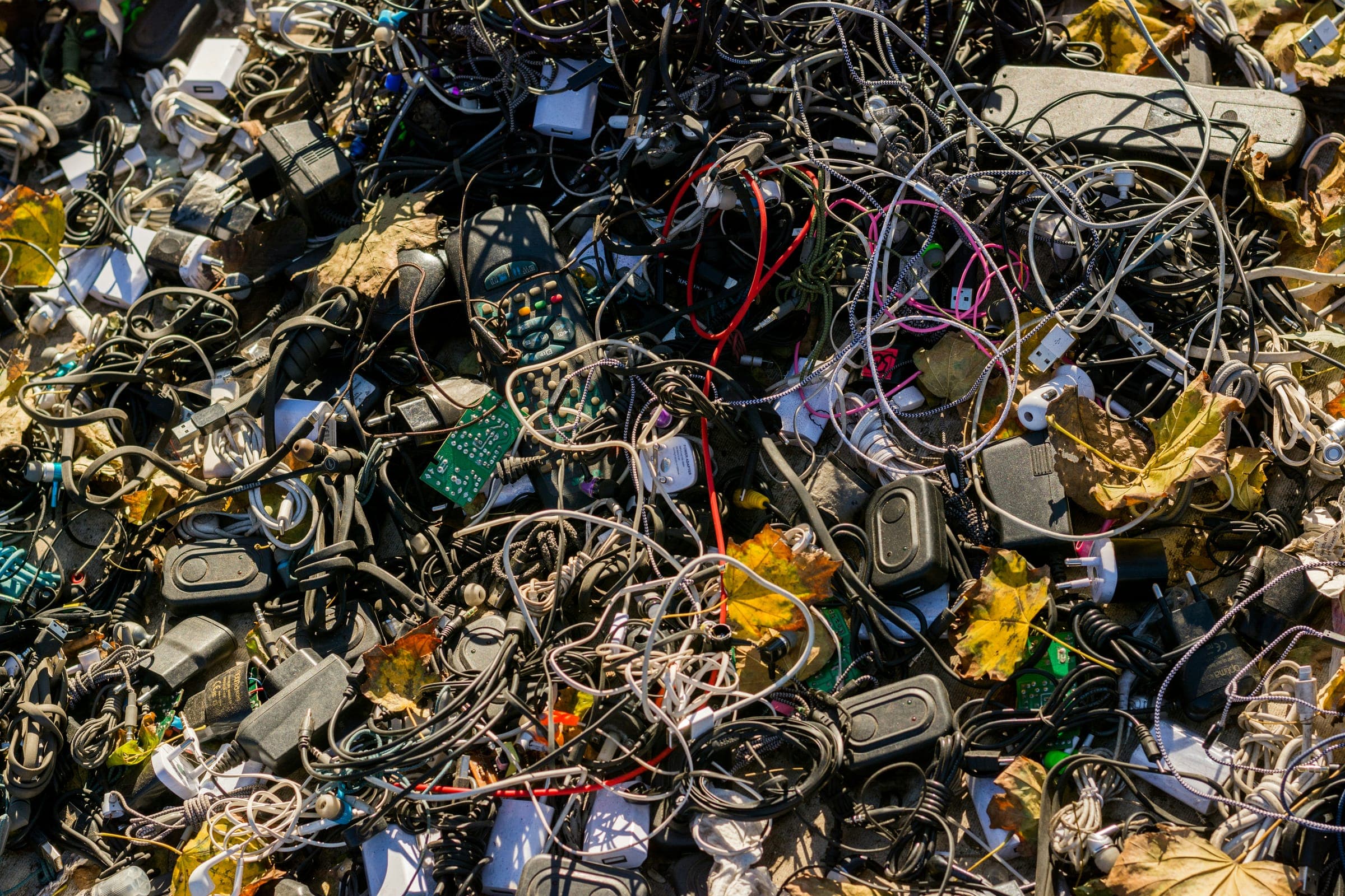 Montón de residuos electrónicos: cables, cargadores, placas y piezas pequeñas mezclados